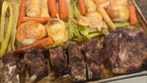 Rostade benbitar med morötter, lök och andra rotfrukter